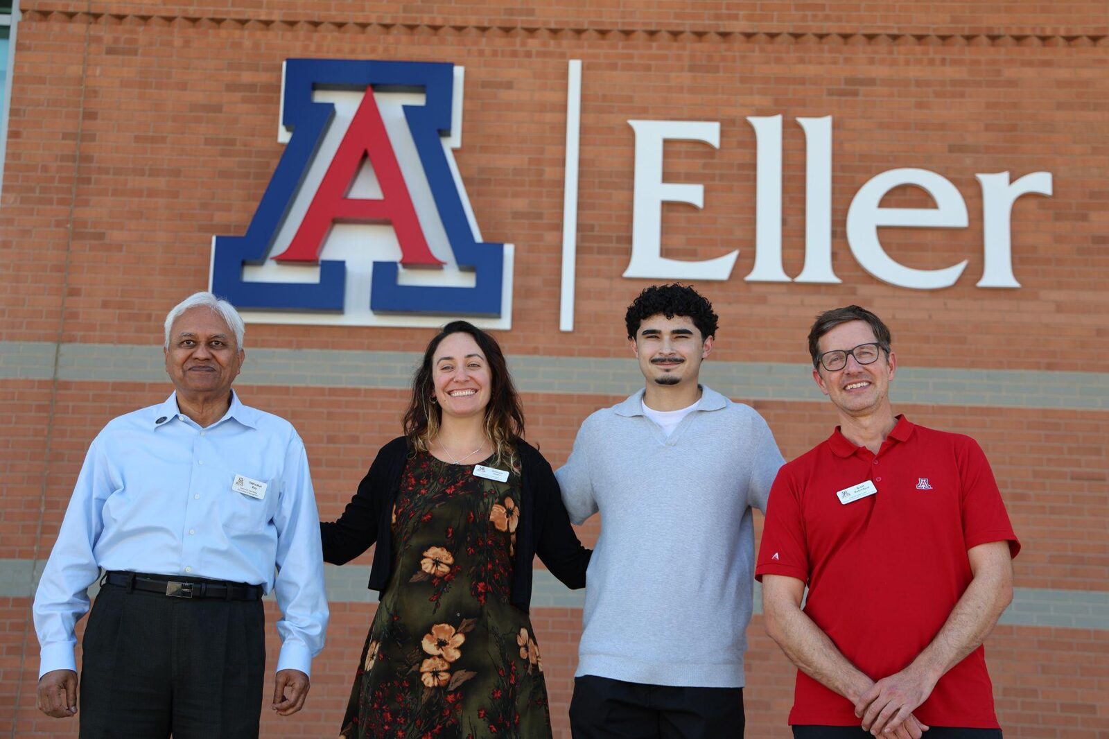 Four people in front of the Eller College of Management sign